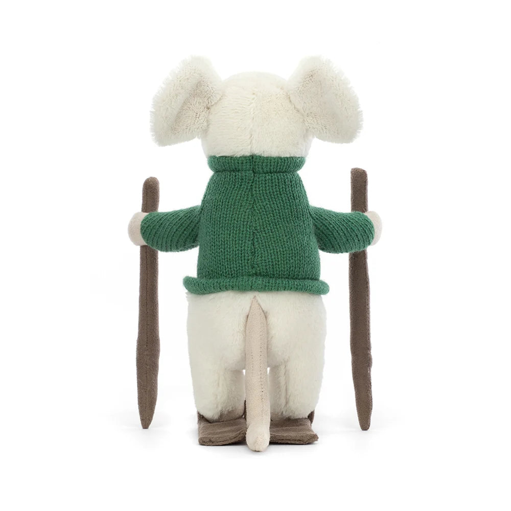 View of backside of toy: An adorable plush toy of a white mouse dressed in a cozy green sweater and skis strapped to its tiny feet. Its white fur contrasts beautifully with the vibrant green sweater. The merry mouse has a cheerful expression, with its sparkling black eyes and a sweet little nose peeking out from its furry face. As it glides down the slopes, the mouse's long tail playfully trails behind.